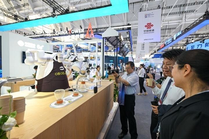 6月20日，與會者品嘗機器人沖調(diào)出的咖啡。新華社記者 孫凡越 攝