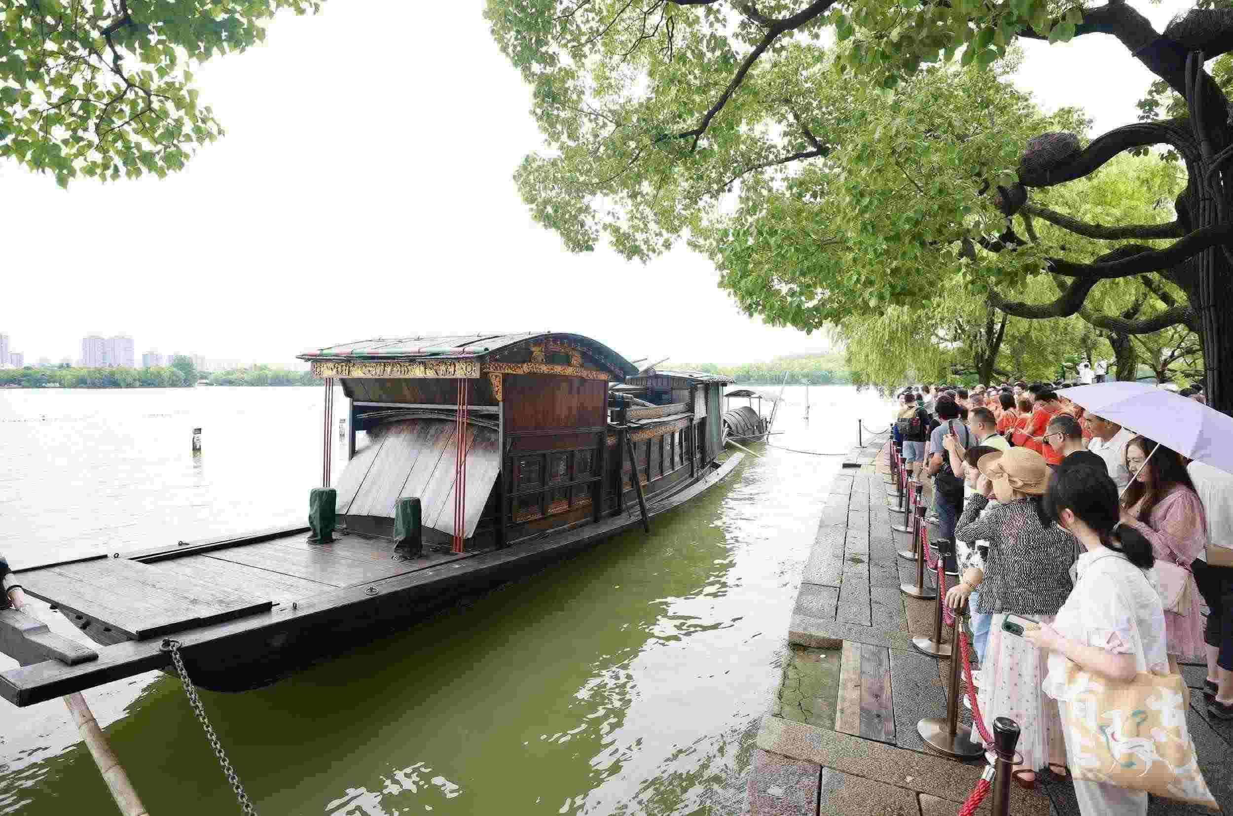 浙江嘉興，游客在南湖景區(qū)湖心島瞻仰紅船，感悟“紅船精神”。（圖片來源：視覺中國(guó)）