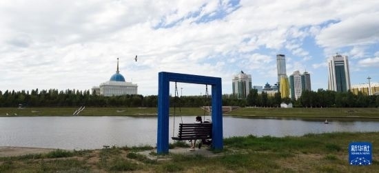 6月30日，一名女子在哈薩克斯坦首都阿斯塔納伊希姆河畔休息。新華社記者 王建華 攝