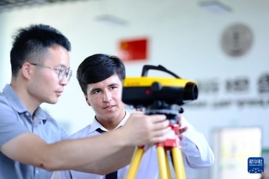6月14日，在塔吉克斯坦首都杜尚別的魯班工坊，來自天津城市建設(shè)管理職業(yè)技術(shù)學院的老師（左）指導學生。新華社記者 鄭開君 攝