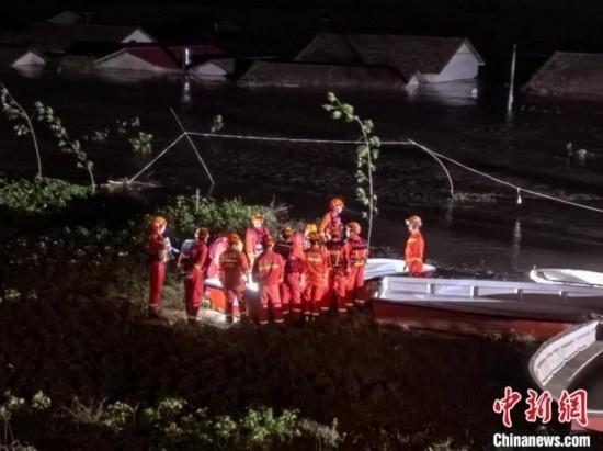  7月6日凌晨3時(shí)，在湖南岳陽華容縣團(tuán)洲垸洞庭湖一線堤防，救援人員剛剛完成一次救援任務(wù)，遠(yuǎn)處是被淹的民房。中新社記者 白祖偕 攝