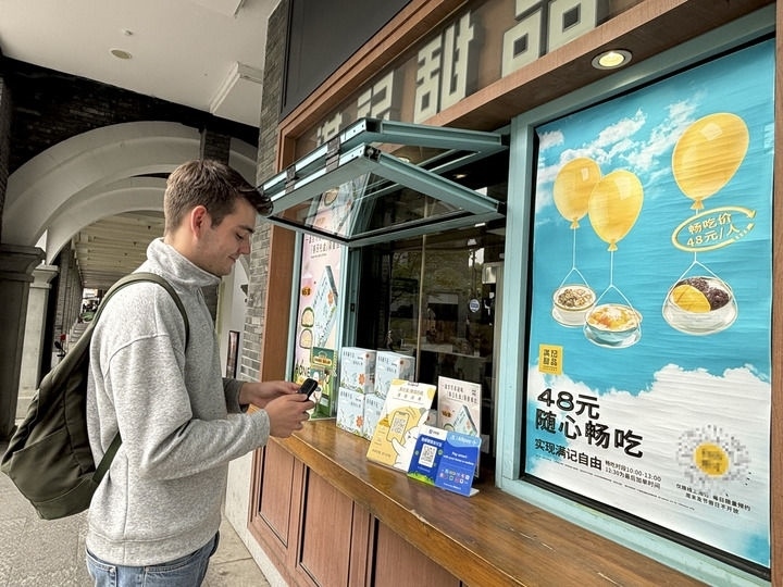 來(lái)自德國(guó)的留學(xué)生理查德在杭州西湖邊一家商鋪使用支付寶掃碼支付（2024年4月11日攝）。新華社發(fā)