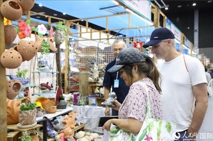 游客在蘭納博覽會(huì)特色展位上選購(gòu)工藝品。人民網(wǎng)記者楊一攝