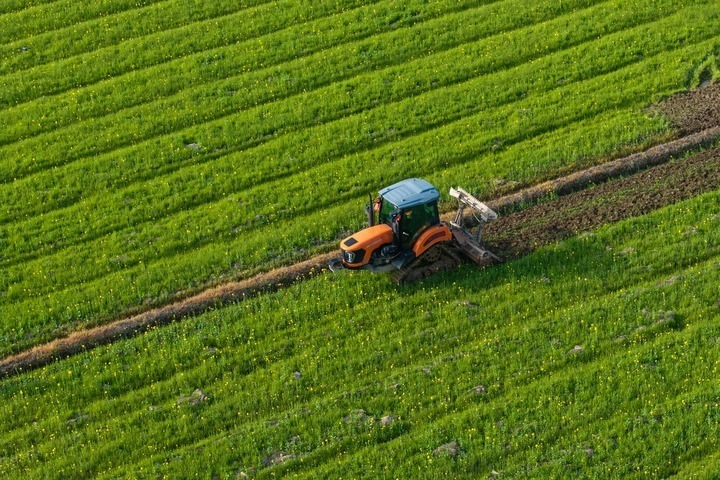 2024年3月19日，在湖南省常德市鼎城區(qū)謝家鋪鎮(zhèn)港中坪村，村民駕駛農(nóng)機(jī)翻耕田地（無人機(jī)照片）。新華社記者 陳思汗 攝