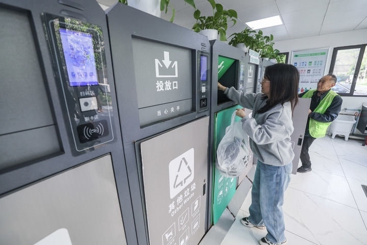 2024年4月10日，在浙江省湖州市吳興區(qū)飛英街道新華府小區(qū)內(nèi)，居民在垃圾分類智能系統(tǒng)的指導(dǎo)下進(jìn)行垃圾分類投放，居民的投放情況將實(shí)時(shí)匯總到智慧服務(wù)平臺(tái)，會(huì)有相應(yīng)的積分獎(jiǎng)勵(lì)。新華社記者 徐昱 攝