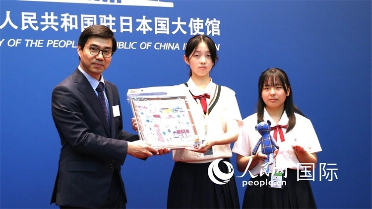 日本小大使向中國駐日本大使館臨時代辦施泳贈送當?shù)靥厣Y品。人民網(wǎng) 許可攝