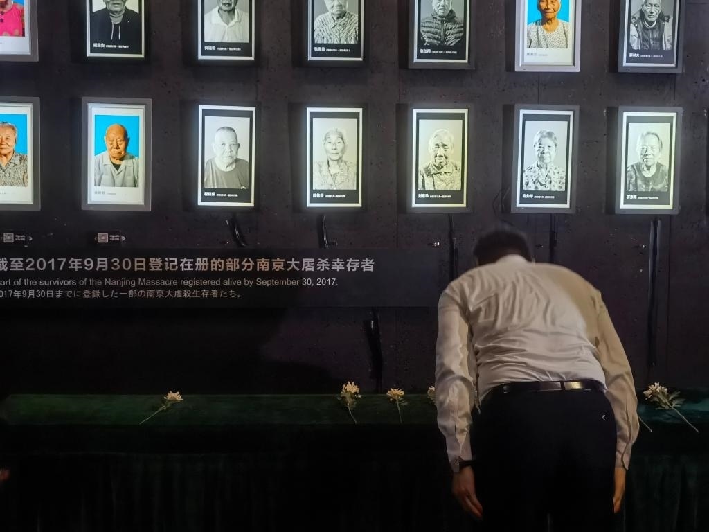 7月18日，人們向離世的南京大屠殺幸存者獻花、鞠躬。新華社記者邱冰清 攝