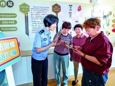 浙江湖州民警指導(dǎo)居民加入湖州“e企安”微信群，實(shí)時(shí)接收反詐信息。新華社發(fā)