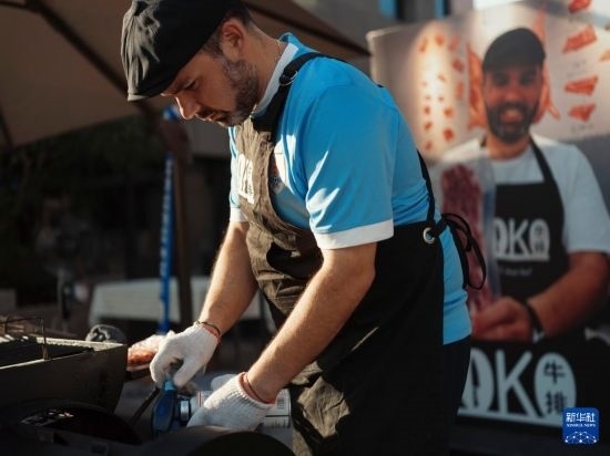 7月19日，在蕪湖古城，馬丁在當(dāng)天舉行的啤酒節(jié)上制作牛排。新華社發(fā)（繆雨晨 攝）