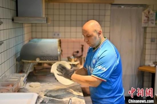 近日，韋榮耀在自家披薩小店內(nèi)忙活。俞靖 攝