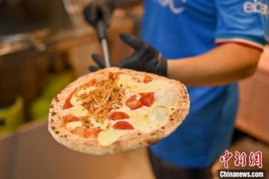 近日，韋榮耀展示他制作的“老友味”披薩。 俞靖 攝