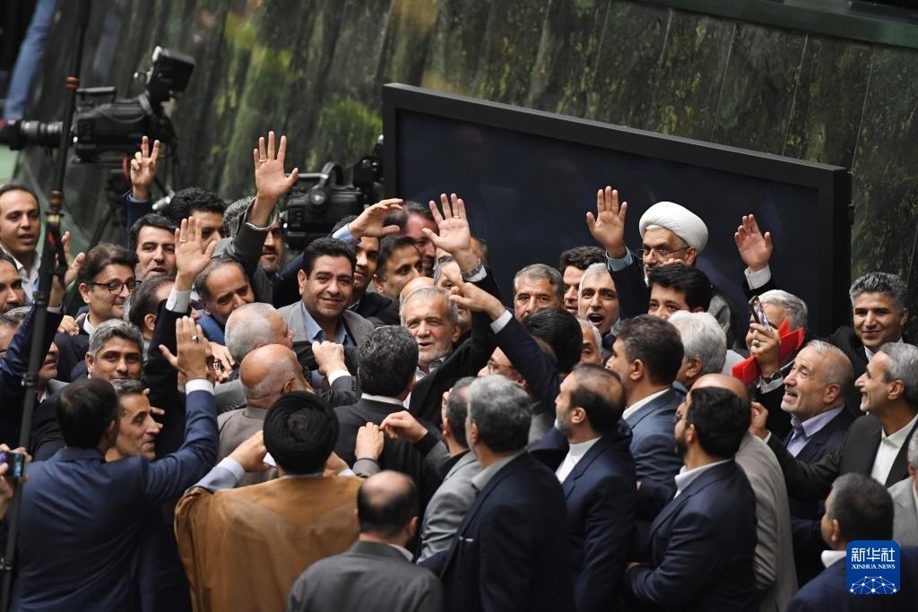 7月30日，在伊朗德黑蘭的伊朗議會(huì)，佩澤希齊揚(yáng)（中）離開總統(tǒng)就職典禮現(xiàn)場(chǎng)時(shí)揮手致意。新華社記者 沙達(dá)提 攝