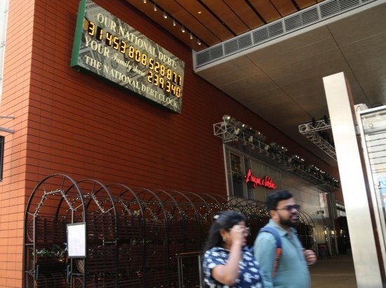 2023年5月29日，人們經(jīng)過美國紐約曼哈頓的“國債鐘”。“國債鐘”是一個(gè)大型計(jì)數(shù)器，它實(shí)時(shí)更新美國的公共債務(wù)總額，并顯示出每個(gè)美國家庭所要負(fù)擔(dān)的數(shù)額。 新華社記者劉亞南攝