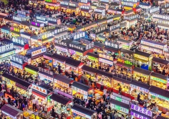 2024年4月21日，人們?cè)诤颖笔≌h小商品夜市品嘗美食（無(wú)人機(jī)照片）。新華社發(fā)（武志偉 攝）