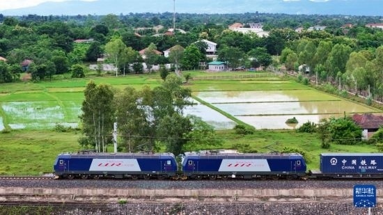 8月5日，由老撾籍火車司機(jī)獨立駕駛的滿載貨物的列車駛出萬象站，向中國昆明進(jìn)發(fā)（無人機(jī)照片）。新華社發(fā)（楊永全 攝）