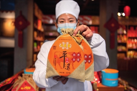 在位于山西省晉中市平遙縣的平遙古城南大街的一家平遙牛肉店內(nèi)，工作人員展示一款牛肉產(chǎn)品（資料照片）楊晨光攝 / 本刊