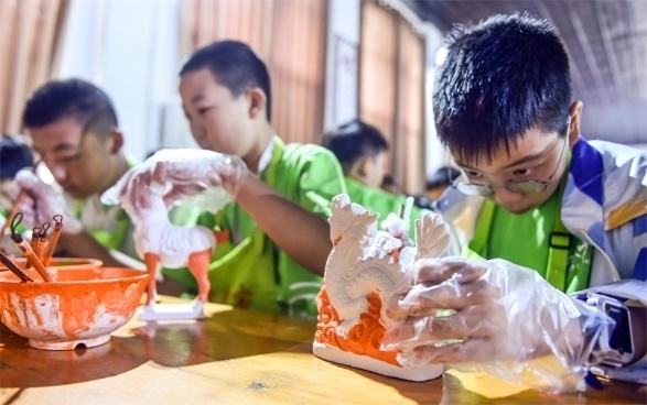 小朋友們?cè)诼尻?yáng)市孟津區(qū)朝陽(yáng)鎮(zhèn)南石山村體驗(yàn)唐三彩素胎施釉技藝。圖片來(lái)源：視覺(jué)中國(guó)