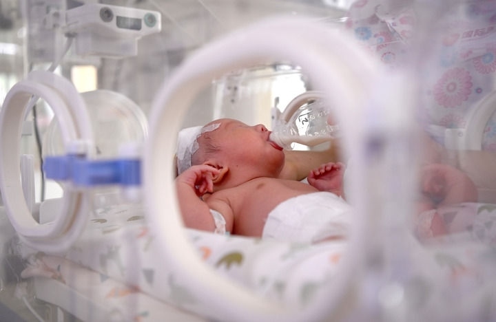 2024年6月1日，在西安國(guó)際醫(yī)學(xué)中心醫(yī)院新生兒科病房，護(hù)士為新生兒喂奶。 新華社記者 劉瀟 攝