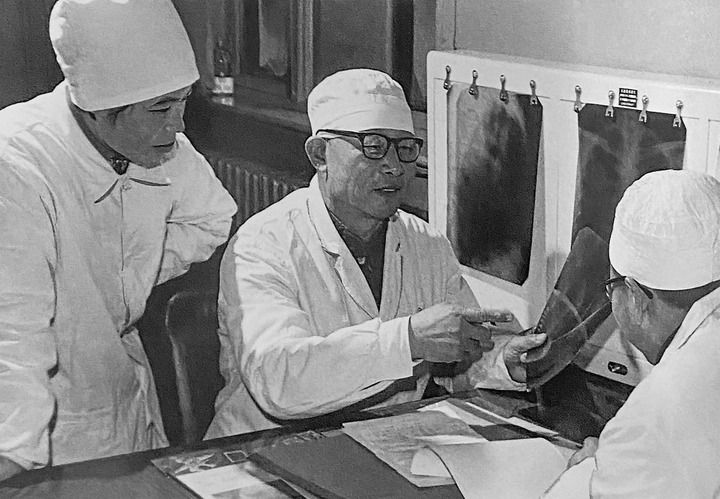 1980年1月16日，中日友好醫(yī)院首任院長(zhǎng)辛育齡（中）在內(nèi)蒙古結(jié)核病院與胸外科醫(yī)師討論病例（翻拍照片）。 新華社發(fā)