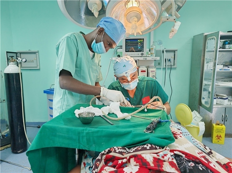 李廣醫(yī)生與當?shù)蒯t(yī)生在做手術(shù)中。中國援桑醫(yī)療隊供圖