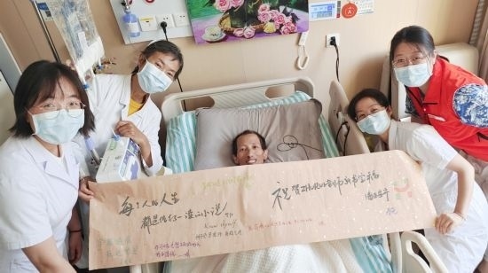7月26日，海淀醫(yī)院安寧療護(hù)科醫(yī)護(hù)團(tuán)隊(duì)為朱銳送來一條寫滿祝福的橫幅。（受訪者供圖）