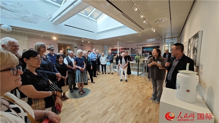 參展人、景德鎮(zhèn)陶瓷大學(xué)美術(shù)學(xué)院副院長(zhǎng)邵長(zhǎng)宗（右一）向來賓介紹參展作品。人民網(wǎng)記者 殷淼攝