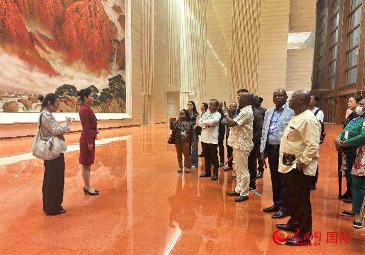 代表團(tuán)在入口處聽取講解。人民網(wǎng) 曹欣悅攝