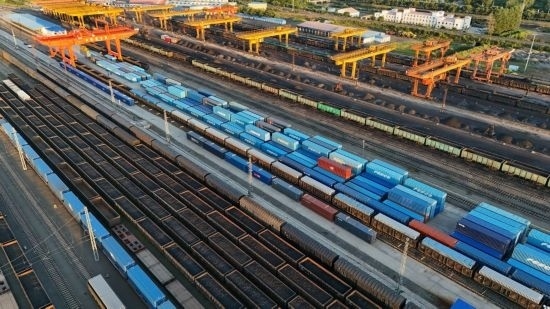 這是2024年8月14日在黑龍江綏芬河鐵路口岸集裝箱換裝場拍攝的集裝箱換裝作業(yè)現(xiàn)場（無人機照片）。今年前七個月，綏芬河鐵路口岸開行中歐班列573列，運量達(dá)55246標(biāo)箱，同比分別增長23%和18%，班列數(shù)量持續(xù)保持高位運行。