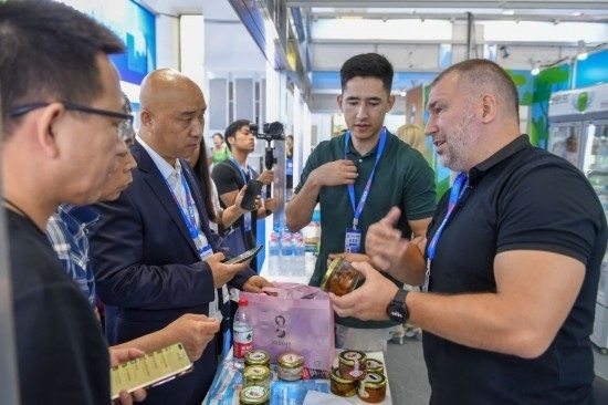 2023年8月23日，在第十四屆中國—東北亞博覽會東北亞商品館，俄羅斯參展商向參觀者介紹商品。