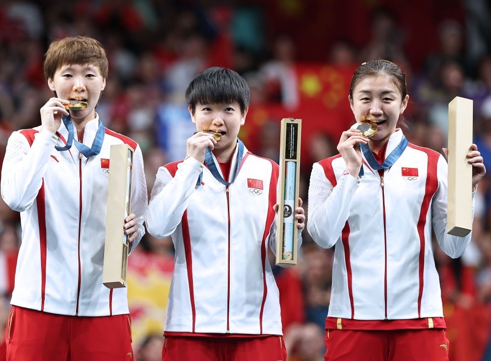 冠軍中國隊選手王曼昱、孫穎莎、陳夢（從左至右）在巴黎奧運會乒乓球女子團體頒獎儀式上（2024年8月10日攝）。新華社記者 王東震 攝