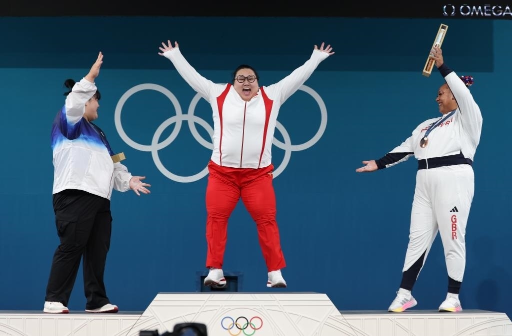 中國選手李雯雯（中）在巴黎奧運會舉重女子81公斤以上級頒獎儀式中登上領獎臺（2024年8月11日攝）。新華社記者 楊磊 攝