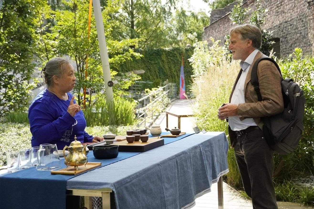 在博物館的戶外花園來賓品味中國茶藝。比利時維他命文化傳媒供圖
