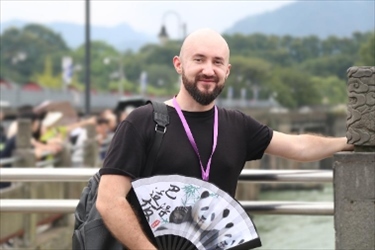 俄羅斯塔斯社執(zhí)行編輯葉夫根尼·扎多羅日內(nèi)在都江堰魚(yú)嘴拍照留念。（李佩藺 攝）