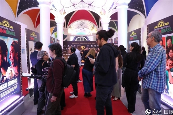為期4天的第三屆中國－巴西電影展期間，來自中巴兩國的14部參展影片受到巴西電影愛好者和社會各界人士好評，圖為當(dāng)?shù)赜^眾在影展舉辦地巴西里約熱內(nèi)盧勞拉—阿爾維姆文化之家的迎賓廳欣賞參展電影海報。 人民網(wǎng)記者 陳一鳴攝