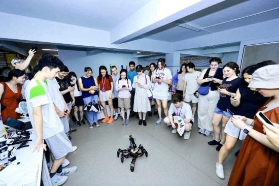 8月25日，中外青年在浙江杭州觀看機(jī)器人表演。新華社發(fā)（清華大學(xué)供圖）