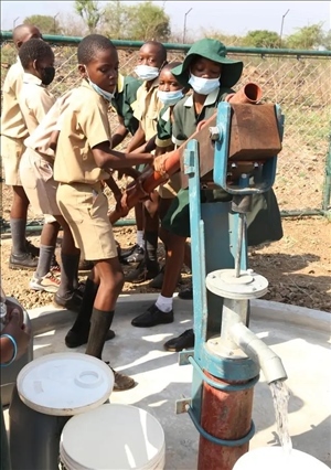 △2021年11月，在津巴布韋南馬塔貝萊蘭省省會關(guān)達的塞農(nóng)多小學(xué)，學(xué)生從中國援建水井里打水。