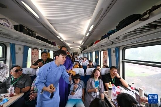 9月7日，相聲演員在S910列車上為旅客表演快板。