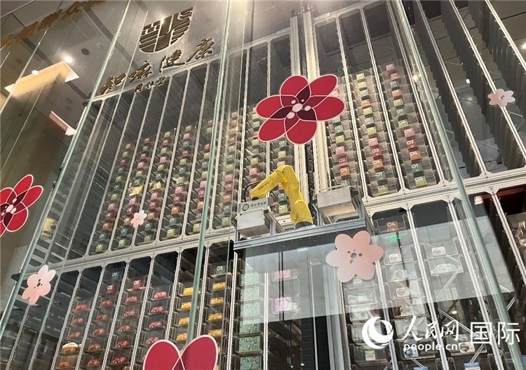 6. 機(jī)械臂正在取貨。（人民網(wǎng)記者陳思 攝）