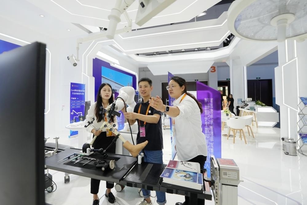 9月11日，一位媒體記者（中）在2024年服貿(mào)會(huì)國(guó)家會(huì)議中心會(huì)場(chǎng)體驗(yàn)北京納通科技集團(tuán)有限公司的膝關(guān)節(jié)置換手術(shù)機(jī)器人。新華社記者鞠煥宗 攝