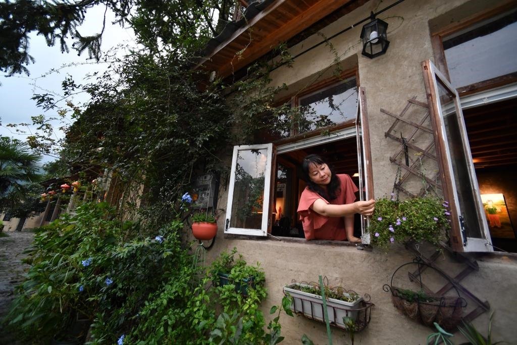 8月29日，在福建省屏南縣熙嶺鄉(xiāng)，龍?zhí)洞濉靶麓迕瘛泵泛暝诖蚶碜约航?jīng)營(yíng)的民宿外墻裝飾花盆。新華社記者姜克紅 攝