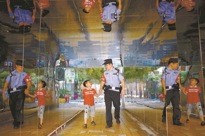 ?7月16日，重慶市公安局江北區(qū)分局一名民警在巡邏途中遇到一個獨自玩耍的小男孩，民警將其送回家。王洪平攝