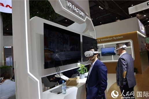 外國(guó)觀眾在通過(guò)VR參觀中國(guó)風(fēng)電企業(yè)智慧工廠。人民網(wǎng)記者 劉仲華攝