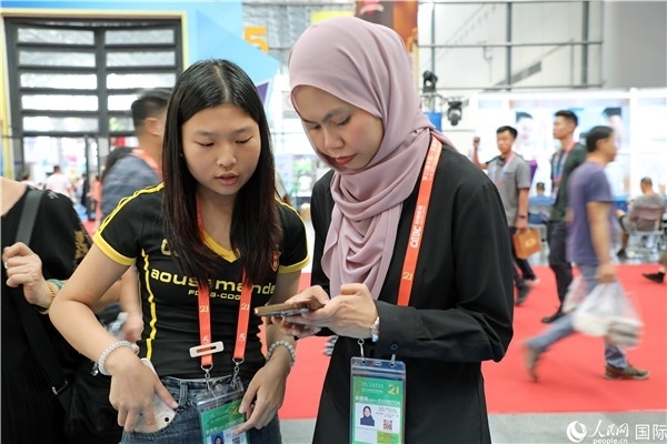 東博會(huì)現(xiàn)場(chǎng)，馬來西亞展商在同中方工作人員交談。人民網(wǎng)記者 趙益普攝