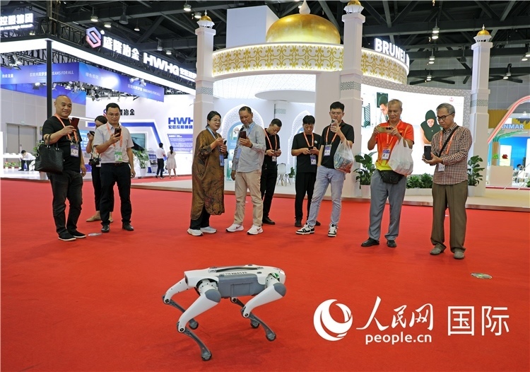 東博會(huì)上，觀眾正在參觀一只機(jī)器狗。綠色能源、新能源汽車、綠色農(nóng)產(chǎn)品等成為本屆東博會(huì)觀眾關(guān)注的焦點(diǎn)。人民網(wǎng)記者 趙益普攝