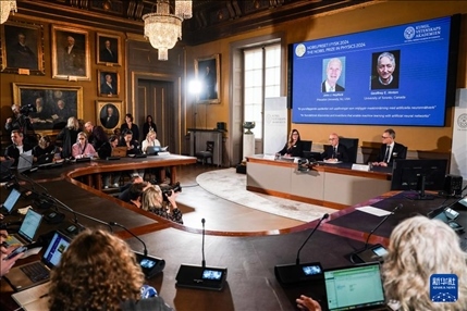 10月8日，在瑞典斯德哥爾摩舉行的2024年諾貝爾物理學(xué)獎公布現(xiàn)場，屏幕顯示獎項(xiàng)得主美國普林斯頓大學(xué)的約翰·霍普菲爾德和加拿大多倫多大學(xué)的杰弗里·欣頓。新華社記者 彭子洋 攝