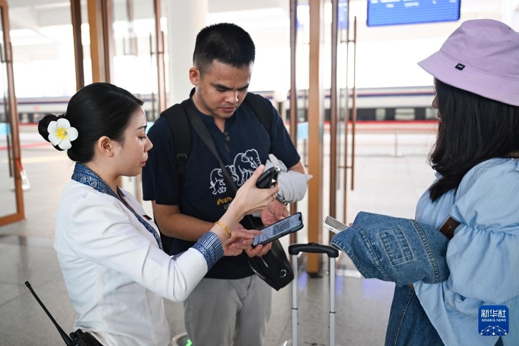 10月12日，在老撾萬(wàn)象中老鐵路萬(wàn)象站，工作人員檢驗(yàn)乘客車票。新華社記者 程一恒 攝