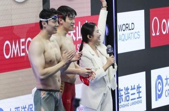  10月18日，汪順（左）和潘展樂在男子100米混合泳決賽后。新華社記者 方喆 攝