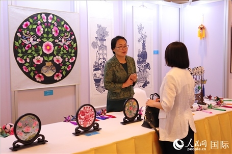 青海非遺文化傳承人向嘉賓介紹展品。人民網(wǎng)實(shí)習(xí)生姚欣可攝