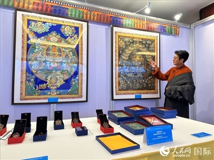 熱貢藝術(shù)國家級代表性傳承人夏吾角向嘉賓介紹作品。人民網(wǎng)記者 簡承淵攝