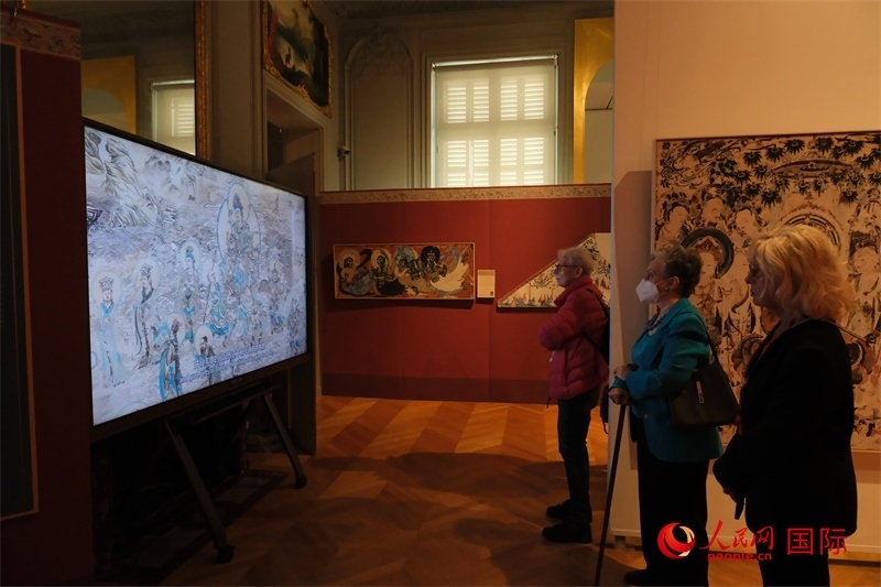 觀眾在展臺(tái)觀看錄像講解。人民網(wǎng)記者 尚凱元攝